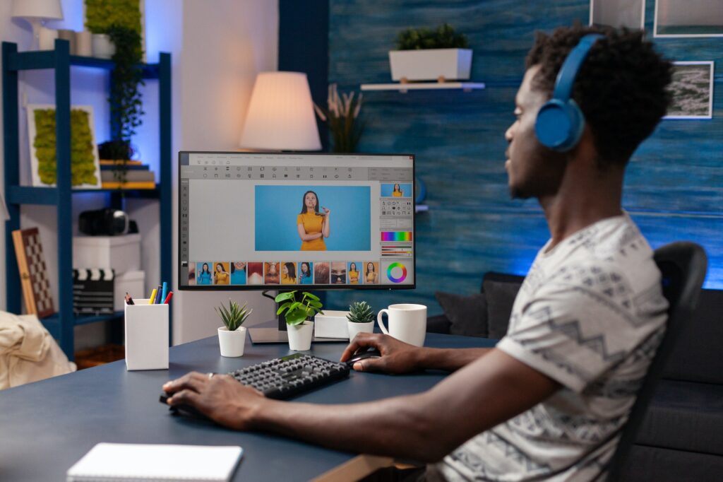 African american editor with headset doing retouching on creative photos